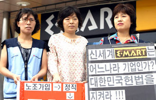 해고됐다 복직된 뒤 5일 만에 다시 계약만료 통보를 받은 고경희, 이명희, 최옥화(왼쪽부터)씨가 13일 오후 경기도 용인 수지 이마트 앞에서 항의 팻말을 들고 시위를 벌이고 있다. 용인/김정효 기자