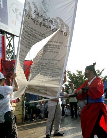 12일 인천 자유공원에서 열린 맥아더 동상 철거 집회에서 장군으로 분장한 참가자가 맥아더의 포고문이 적힌 현수막을 찢고 있다.(인천=연합뉴스)