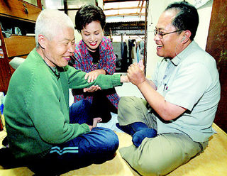 불의의 사고로 하반신이 마비된 김윤규(오른쪽) 목사가 자원봉사자와 함께 전주의 한 독거노인을 찾아 물리치료를 해주며 환하게 웃고 있다.연합뉴스