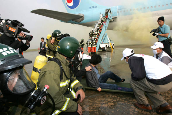 아·태경제협력체(APEC) 정상회의를 앞두고 26일 오후 서울 김포공항 경항공기 계류장에서 열린 ‘항공기 사고수습 종합훈련’에서 활주로를 이탈한 비행기에서 화재가 발생한 가상상황에서 훈련 참가자들이 부상자를 구조해 구급조치를 취한 뒤 대피시키고 있다. 김진수 기자 jsk@hani.co.kr