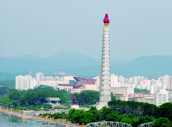 전체 높이가 170미터에 이르는 주체사상탑. 그 뒤로 과감한 지붕의 조형미를 뽐내는 청년 중앙회관이 보인다.