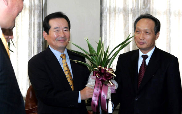 정세균 열린우리당 의장 겸 원내대표가 3일 오전 국회 당 의장실에서 노무현 대통령의 의장 취임 축하난을 이병완 청와대 비서실장을 통해 전달받으며 웃고 있다. 이종찬 기자 <A href=\"mailto:rhee@hani.co.kr\">rhee@hani.co.kr</A>