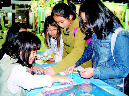 지난 9일 친환경상품 전시회장을 찾은 서울 상계동 동일초등학교 5학년1반 어린이들이 에너지시민연대가 설치한 전시관에서 태양전지로 움직이는 장난감 부품들을 구경하고 있다.