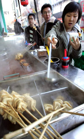 기온이 뚝 떨어지고 바람이 불어 쌀쌀한 날씨를 보인 15일 아침 서울 영등포구의 한 포장마차를 찾은 시민들이 따뜻한 어묵 국물로 몸을 녹이고 있다. 김진수 기자 jsk@hani.co.kr