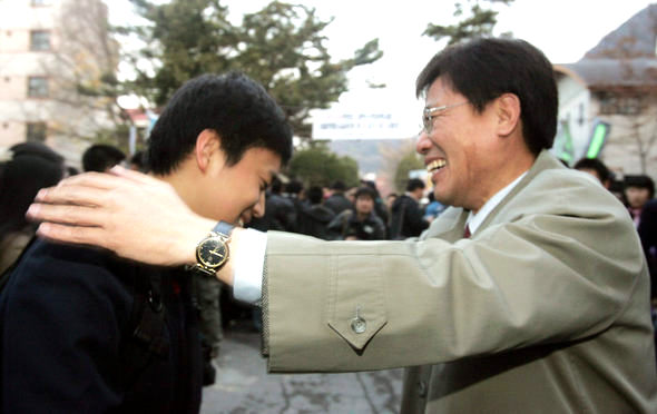 2006학년도 대학수학능력시험이 치러진 23일 오전 서울 경복고 시험장 입구에서 동성고의 한 교사가 수험장에 들어가는 제자의 어깨를 두드리며 격려하고 있다. 김종수 기자 <A href=\"mailto:jongsoo@hani.co.kr\">jongsoo@hani.co.kr</A>