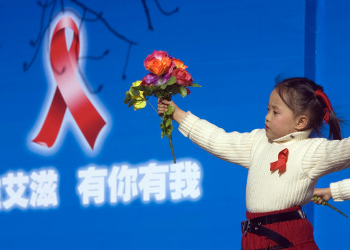 1일 중국 베이징에서 열린 ‘세계 에이즈의 날’ 기념공연에서 한 중국 어린이가 ‘그 누구나 에이즈에 대한 각별한 관심을’이란 구호가 적힌 무대에서 공연을 하고 있다. 중국은 앞으로 5년간 에이즈감염자 수를 150만명 이하로 유지하지 못하면 사회적 불안과 경제위축을 초래하게 될 것이라고 중국 고위 보건당국자가 30일 밝혔다. 베이징/AP 연합