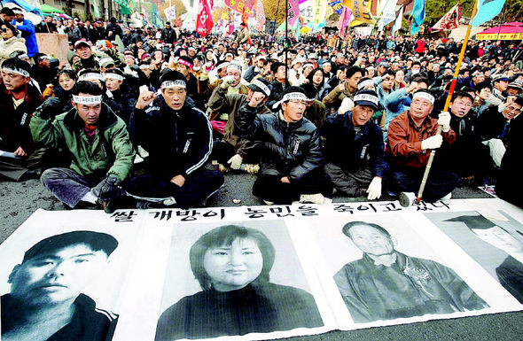 전국농민회총연맹 등 농민단체와 농민들이 1일 오후 서울 대학로에서 연 ‘전용철 농민 추모·쌀협상 국회 비준 무효 전국농민대회’ 참석자들이 전용철·오추옥·하신호·전용품(왼쪽부터)씨 등 농민집회에 참석한 뒤 숨지거나 스스로 목숨을 끊은 농민들의 영정을 펼쳐놓고 구호를 외치고 있다. 김정효 기자 hyopd@hani.co.kr