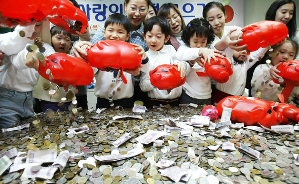 1일 오전 서울 성동구청에서 서울 성동구 구립보육시설연합회 소속 어린이집 어린이들이 지난 1년 동안 돼지저금통에 모은 돈을 쏟아붓고 있다. 어린이 2400여명이 모은 성금은 연말 저소득층 가정 어린이들에게 장학금 등으로 전달할 예정이다. 김정효 기자 hyopd@hani.co.kr