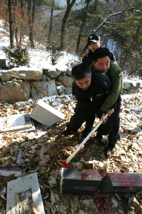 5일 오전 경기 파주시 보광사 경내에서 전향장기수, 남파공작원의 묘비에 곡괭이질을 하는 북파공작원단체 회원을 경찰이 제지하고 있다. 파주/이종찬기자 rhee@hani.co.kr.