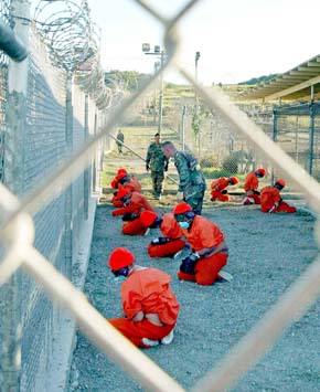 <b>제국에 무릎 꿇린 인권</b> 쿠바 관타나모 미국 해군기지에 수용된 알카에다 조직원들이 철조망으로 둘러싸인 감방 안에서 무릎을 꿇은 채 경비병들의 감시를 받고 있다. <한겨레> 자료사진