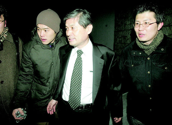 황우석 교수가 18일 오후 서울대 수의대에서 줄기세포 연구 재검증을 위한 서울대 조사위원회의 조사를 받은 뒤 연구팀과 기자들에게 둘러싸인 채 수의대 건물을 나서고 있다. 사진공동취재단