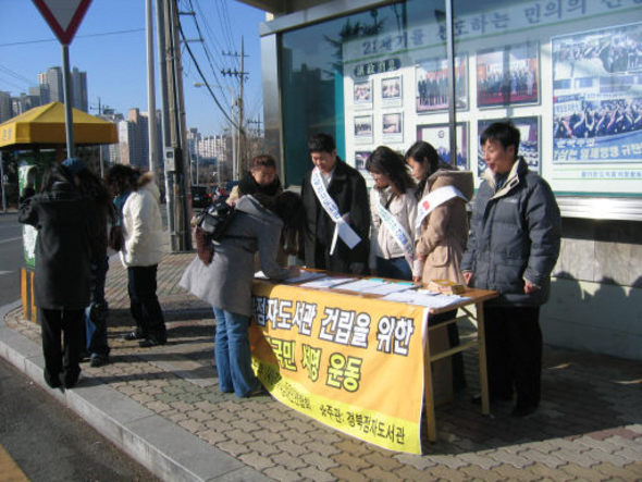 22일 매서운 한파 속에 시각장애인과 자원봉사자들이 경북도청 앞에서 경북점자도서관 건립을 위한 서명운동을 벌이고 있다.