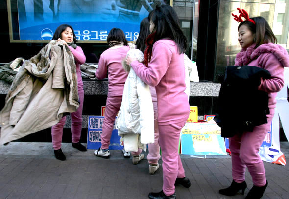 월초부터 시작된 맹추위가 이어지는 가운데 에너지시민연대 회원들이 22일 오전 서울 명동 우리은행 들머리에서 크리스마스 선물로 내복을 권하는 ‘내복입기 캠페인’을 벌인 뒤, 얼른 겉옷을 찾아 입고 있다. 이종근 기자 root2@hani.co.kr