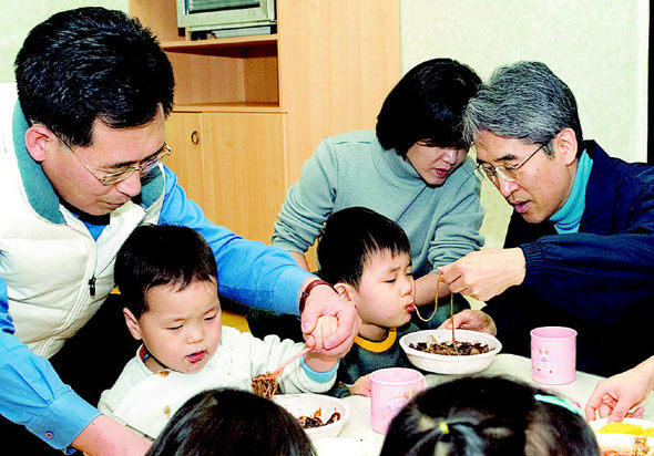 교보생명의 신창재 회장(오른쪽) 등 최고경영자들이 자원봉사팀을 구성해서, 7일 서울 성동구 하왕십리동의 화성영아원을 찾아가 어린이들이 자장면을 먹는 것을 도와주고 있다. 교보생명 제공