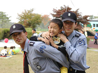 용인교통박물관에서 장애인먼저실천운동본부가 연 ‘2005 장애인먼저실천상 시상식에 참석한 아이들과 한국방송 청원경찰들이 즐거운 시간을 보내고 있다. 한국방송 청원경찰대 제공