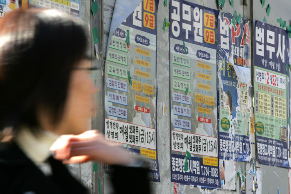 서울 연세대학교 교정에 빼곡히 붙어있는 공무원시험 학원 홍보물 앞을 한 학생이 지나가고 있다. 이정아 기자 leej@hani.co.kr (※ 해당 사진은 기사와 직접적 연관은 없습니다)