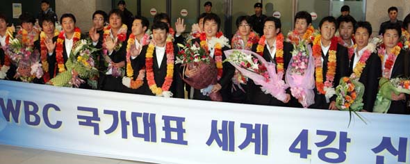 WBC 한국 선수단 귀국 처음으로 열린 야구 최강국 결승전 월드베이스볼클래식(WBC) 4강에 진출하며 야구 붐을 일으킨 한국선수단의 박진만(왼쪽부터), 김재박 감독, 이진영 선수등이 20일 밤 인천공항으로 귀국, 환영객들에게 환하게 웃으며 인사하고 있다. (영종도=연합뉴스)