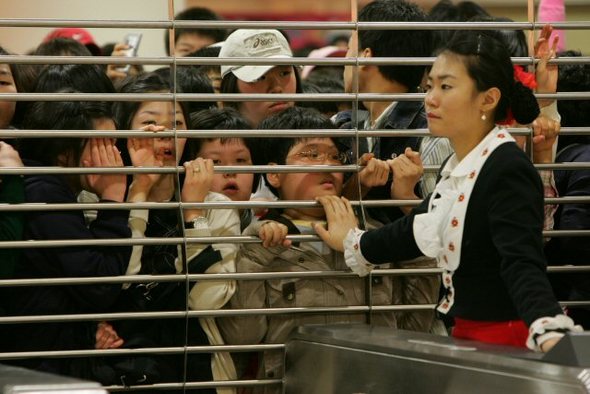 출입인원 통제하는 롯데월드. 26일 무료개방한 잠실 롯데월드에 오전부터 수많은 인파가 몰리자 롯데월드 직원들이 정문 출입구 셔터를 내리고 출입인원을 통제한 가운데 공원을 찾은 시민들이 인파에 밀려 셔터에 매달려 있다. 이날 사고로 35명이 부상을 당하고 미아가 속출하는 등 극심한 혼란이 이어졌다./국민일보 제공(서울=연합뉴스)