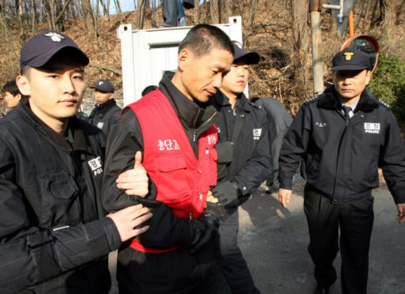 코오롱 구미공장 해고노동자 30여명이 27일 오전 서울 성북동 이웅렬 코오롱 회장 집에 들어가 면담을 요구하다 경찰에 연행돼 나오고 있다. 최일배 노조위원장은 이날 경찰에 연행되기 전 자해를 해 서울 고려대 안암병원에서 치료를 받고 있다. 연합뉴스