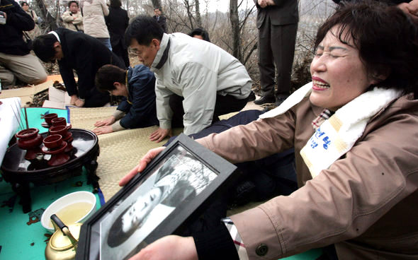 실미도 부대원 가운데 살아 남아 재판을 받은 뒤 사형된 4명의 유해 발굴 작업이 지난 3월28일 오전 서울 구로구 오류동 한 야산에서 시작됐다. 작업 시작 전 고인에게 제사를 지내는 도중 이곳에 묻혀 있을 것으로 추정되는 임선빈(실미도로 끌려갈 당시 18살)씨의 유족이 고인의 영정을 든 채 통곡하고 있다. 김경호 기자 jijae@hani.co.kr