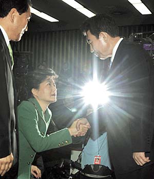 김덕룡 한나라당 의원(오른쪽)이 5.31 지방선거 공건비리와 관련해 13일 국회에서 열린 긴급 의원총회에서 신상발언을 한 뒤 회의장을 떠나며 박근혜 대표에게 악수를 청하고 있다. 김종수 기자 jongsoo@hani.co.kr