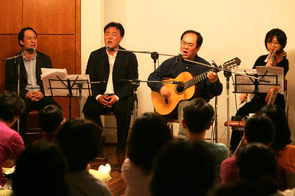 이정선(맨 왼쪽)과 김의철(맨 오른쪽)이 4월 30일 서울 명동 전진상회관에서 노래를 부르고 있다