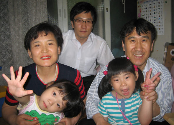 제1회 입양의 날(11일) 국무총리 표창을 받는 이준희(뒷줄 왼쪽)씨의 서울 송파구 집에서 10일 아이들이 사진을 찍는다며 즐거워하고 있다. 왼쪽부터 시계 반대방향으로 막내 은지, 셋째 예지, 남편 김산석씨, 아들 용갑씨.