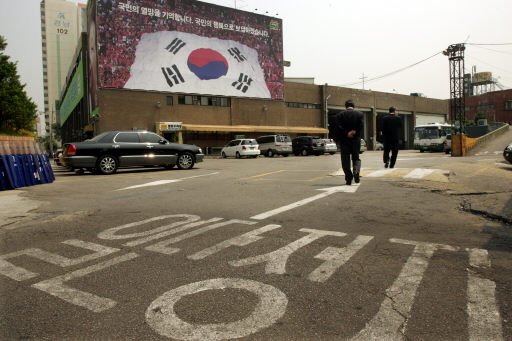 5·31 지방선거 참패로 지도체제와 정책 방향 등을 둘러싼 열린우리당의 내부갈등이 깊어지고 있는 가운데, 5일 오전 서울 영등포동 열린우리당사 정문 앞에서 당직자들이 ‘일단정지’라고 쓰인 노면 교통표시 위를 지나가고 있다. 김종수 기자 <A href=”mailto:jongsoo@hani.co.kr”>jongsoo@hani.co.kr</A>