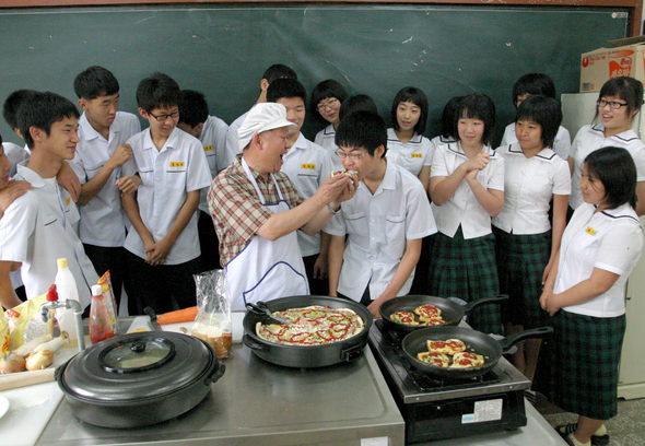 26일 오후 충남 당진군 면천중학교 가사실습실에서 김성삼 교장이 간식으로 피자를 직접 구워 한 학생에게 먹여주고 있다. 당진/송인걸 기자