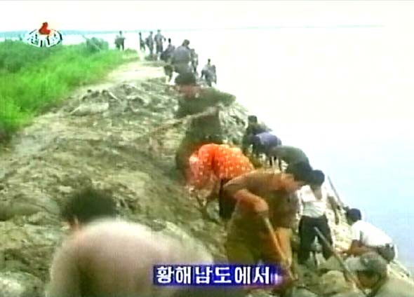 지난달 16~17일 185㎜의 많은 비가 내린 북한 황해남도에서 농민들이 무너진 둑을 복구하고 있다. <조선중앙텔레비전> 촬영/연합뉴스
