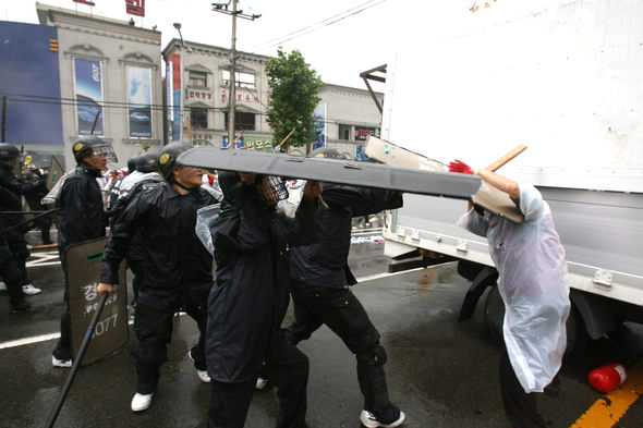 포항건설노조원 하중근씨가 부상을 입고 발견됐던 지난달 16일 오후 3시5분께 사건 현장 근처에서 디지털 카메라로 촬영된 사진. 하중근씨 대책위는 경찰이 한 노조원을 방패로 무차별 공격하고 오른쪽 차량 밑에 경찰용 소화기가 나뒹굴고 있는 이 사진을 제시하며 하씨가 경찰의 폭행으로 숨졌을 가능성이 높다고 주장하고 있다. 하중근씨 대책위 제공