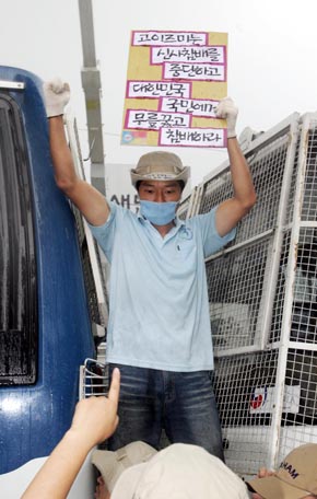 광복절인 15일 오후 서울 광화문 교보문고앞에서 열린 ‘8·15 범국민대회’에 참가한 시민사회단체 회원들이 소낙비를 맞으며 고이즈미 준이치로 일본 총리의 야스쿠니 신사 참배를 규탄하고 있다. 강창광 기자 chang@hani.co.kr