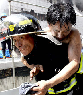 한 소방대원이 1일 오전 서울 종로 쥬얼리시티 신축공사장 화재 현장에서 부상자를 구조하고 있다. 연합뉴스