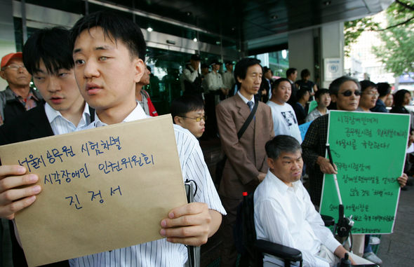 지난 1일 치러진 서울시 공무원 임용시험에서 점역 시험지가 없어 시험을 못 치른 강윤택(28·왼쪽)씨가 2일 오전 서울 중구 국가인권위원회에 장애인 차별에 대한 진정서를 내러 가고 있다. 인권위 앞에서는 ‘장애인차별금지법 제정추진연대’와 전국시각장애인청년연합회 회원들이 서울시를 규탄하는 기자회견을 열었다. 강창광 기자 <A href="mailto:chang@hani.co.kr">chang@hani.co.kr</A>