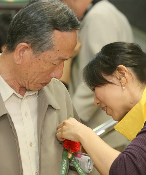 현대건설직원이 10월 2일 노인의 날을 맞아 서울 종로구 경운동 서울노인복지센터에서 어르신에게 카네이션을 달아주고 있다. 박종식 기자 anaki@hani.co.kr