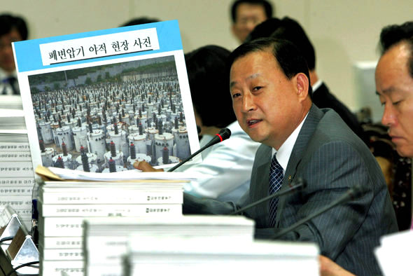 <b>폐변압기 야적 현장-</b>이명규 한나라당 의원이 18일 국회 산자위의 한국전력공사 국정감사에서 환경오염을 초래하고 있는 폐변압기 야적 현장 사진을 공개하며 대책을 추궁하고 있다. 김종수 기자 <A href="mailto:jongsoo@hani.co.kr">jongsoo@hani.co.kr</A>