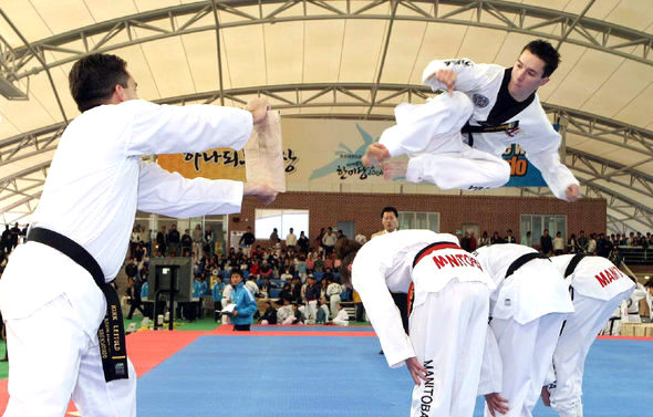 1일 반딧불이의 고장 전북 무주군에서 열린 ‘세계태권도한마당 2006 대회’에서 한 외국인 선수가 사람 위로 뛰어오르며 격파를 하고 있다. 무주/연합뉴스