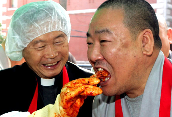 9일 오전 서울 견지동 조계사에서 조계종, 기독교장로회, 대한성공회 등 3개 종교단체가 에스케이텔레콤과 함께 연 ‘행복나눔 김장행사’에서 대한성공회 김재열 신부(왼쪽)가 함께 버무린 김치를 조계사 주지인 원담 스님의 입에 넣어주고 있다. 각 종단의 자원봉사자들이 담근 김장김치는 전국의 소외이웃 1만여명에게 전달될 예정이다. 김종수 기자 <A href="mailto:jongsoo@hani.co.kr">jongsoo@hani.co.kr</A>