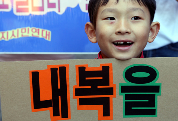 에너지시민연대 회원들이 9일 오전 서울 명동 우리은행 들머리에서 겨울철 내복입기 켐페인에서 참석한 한 아이가 환하게 웃고 있다. 김봉규 기자 bong9@hani.co.kr