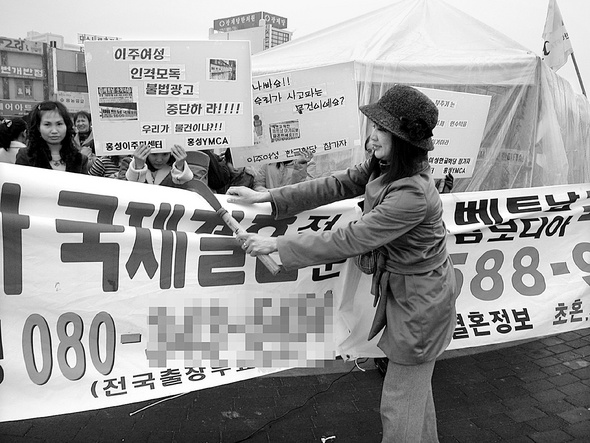 동남아에서 충남 홍성으로 시집와 생활하고 있는 한 이주여성이 7일 자신들을 상품으로 전락시키고 매매혼을 부추기는 국제결혼 알선업체의 플래카드를 낫으로 찢고 있다. 홍성/연합뉴스