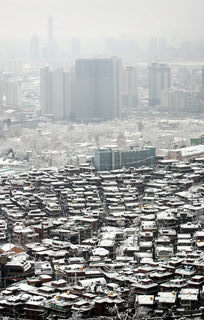 한국 경제에 다시 위기가 찾아오면 그 진원지는 집값 거품과 가계 빚이 될 것이라는 경고가 나오고 있다. 눈이 내린 17일 서울 남산 남쪽 산책로 전망대에서 바라본 해방촌 단독주택 너머로 높이 치솟은 용산구 주상복합아파트와 그 뒤편으로 여의도의 고층 빌딩들이 보인다. 김봉규 기자 bong9@hani.co.kr