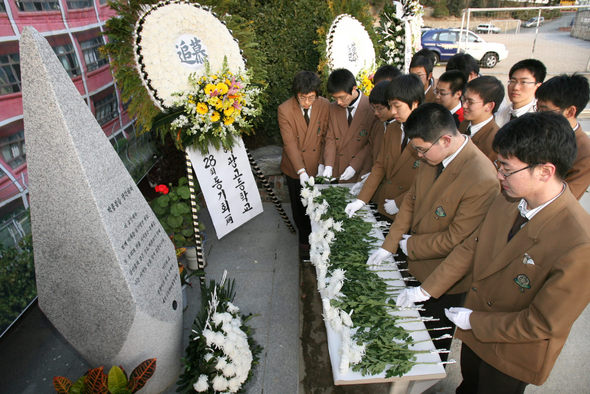 고 박종철씨 20주기 추모제가 지난 13일 오후 모교인 부산 중구 보수동 혜광고에서 열렸다. 혜광고 재학생들이 선배 박씨의 추모비에 헌화하고 있다. 부산/연합뉴스