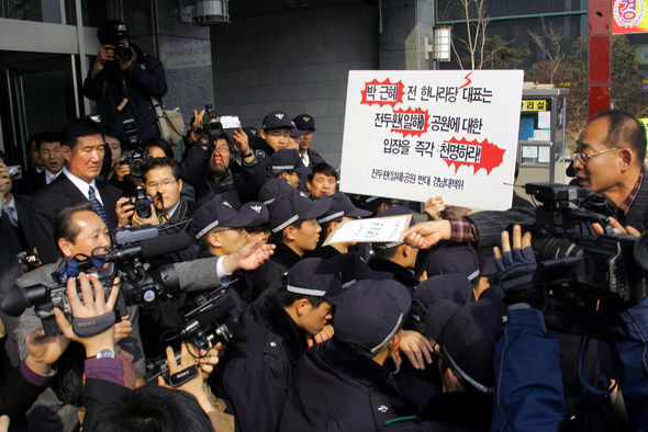 지난 7일 오후 마산을 방문중인 박근혜 전대표에게 공개질의서를 전달하기 위해 모인 전두환(일해)공원반대 경남대책위 관계자들이 리베라호텔 앞에서 박 전대표를 대신해 나온 한나라당 김학송 의원(왼쪽 손 뻗은 이)한테 질의서를 전달하고 있다. 마산/연합뉴스