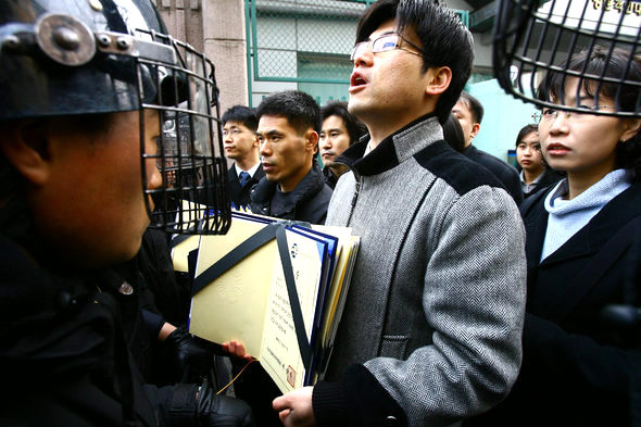 ‘사회과 교육과정 정상화를 위한 비상대책위원회’ 소속 중·고교 사회과 교사들이 22일 오전 서울 세종로 정부중앙청사 뒷문에서 교육부에 부총리 상 및 교육부장관 상을 반납하려다 경찰의 제지를 받고 있다. 연합뉴스