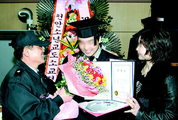 23일 충남 천안백석문화대 신월캠퍼스 학위수여식에서 수석 졸업한 정강준(25·가운데)씨가 김정오(왼쪽) 교위와 어머니의 축하를 받고 있다.