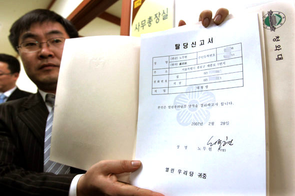 열린우리당 한 당직자가 28일 서울 영등포동 당사에서 청와대에서 보내온 노무현 대통령의 열린우리당 탈당신고서를 보도진에게 보여주고 있다. 김종수 기자 