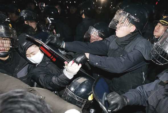 지난 10일 서울 도심에서 열린 한-미 자유무역협정 반대 시위 도중 한 시위 참가자가 경찰들에게 둘러싸여 방패 등으로 집단 구타를 당하고 있다. AP 연합