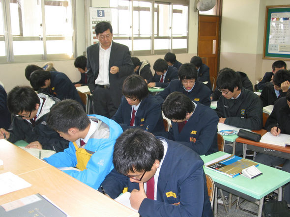 서울 동북고 3학년 2반 학생들이 경제수업시간에 권영부 교사가 지켜보고 있는 가운데 신문기사를 읽은 뒤 자신의 생각을 쓰고 있다.