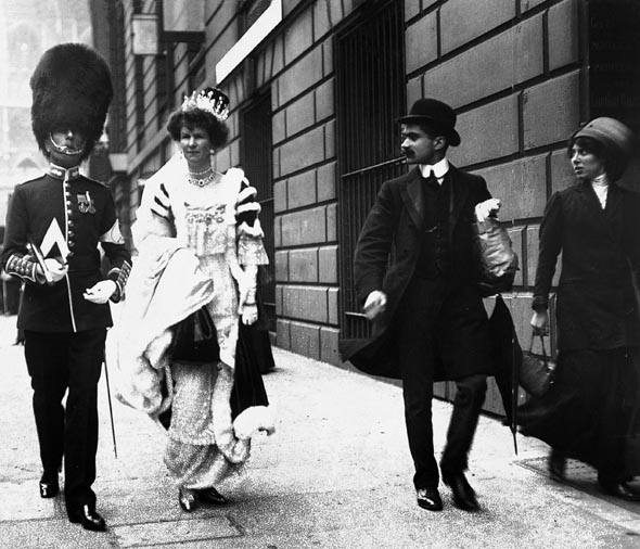 한 왕실 근위대원과 귀족 부인이 1911년 조지 5세의 즉위식에 참석하기 위해 웨스트민스터 사원으로 들어가는 것을, 옆에 지나가던 그들보다 덜 고귀한 신분의 백성들이 쳐다보고 있다. <북폴리오> 제공