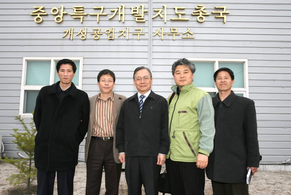 지난달 30일 오후 개성 중앙특구개발지도총국 사무실 앞에서 국내외 언론 사상 처음으로 개성공단을 숙박취재한 <한겨레> 취재팀이 김동근 개성공업지구관리위원회 위원장 및 북쪽 관계자들과 기념사진을 찍었다. 왼쪽에서 두번째부터 이용인 통일팀 기자, 김동근 위원장, 김봉규 사진부 기자. 양끝에 서 있는 이들은 취재기간에 동행한 북쪽 총국 소속 참사들이다. 개성공업지구관리위원회 제공